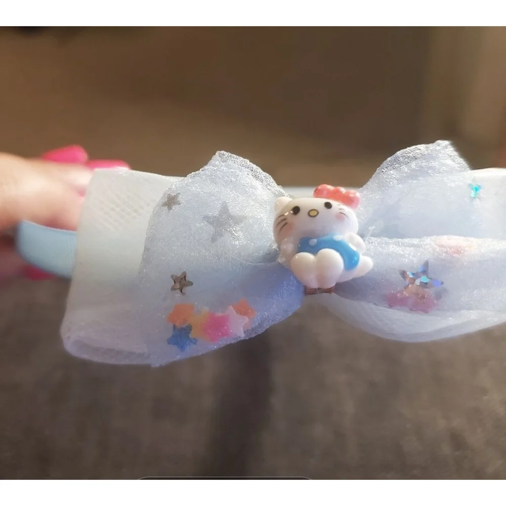 Four Hello Kitty headbands with small figurine